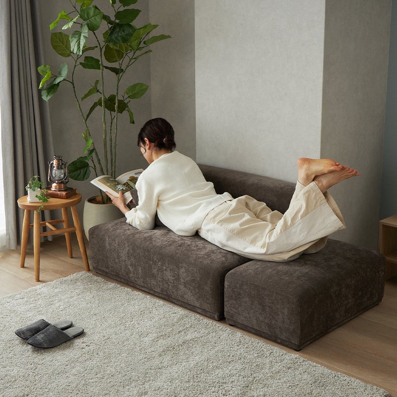 ダークブラウンのソファに寝転んでいる様子